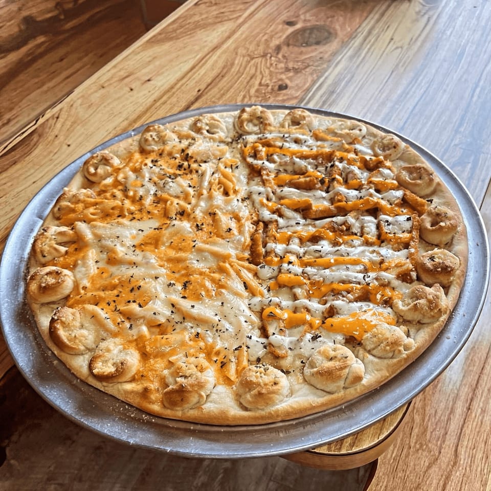 Capri Pizza's mac and cheese and buffalo chicken pizza with garlic knot crust on a wooden table.